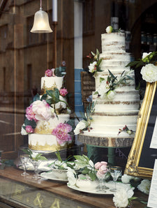 Wedding cakes decorated with flowers in the window of Fitzbillies Cambridge cake shop