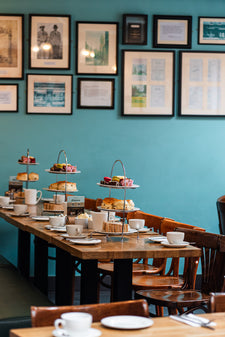 Traditional afternoon tea in Cambridge for a large group laid out with tiered stands of scones, sandwiches and cake