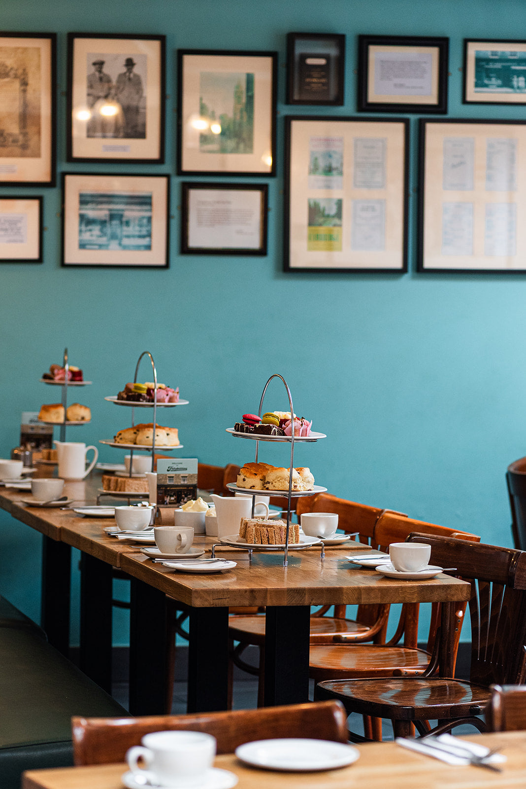 Traditional afternoon tea in Cambridge for a large group laid out with tiered stands of scones, sandwiches and cake
