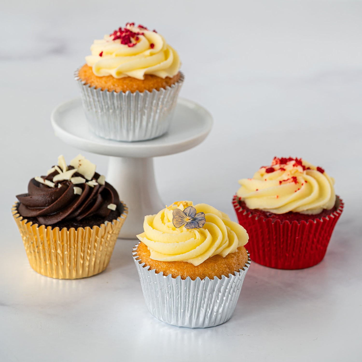 Four wedding cake sample cupcakes with different icing decorations
